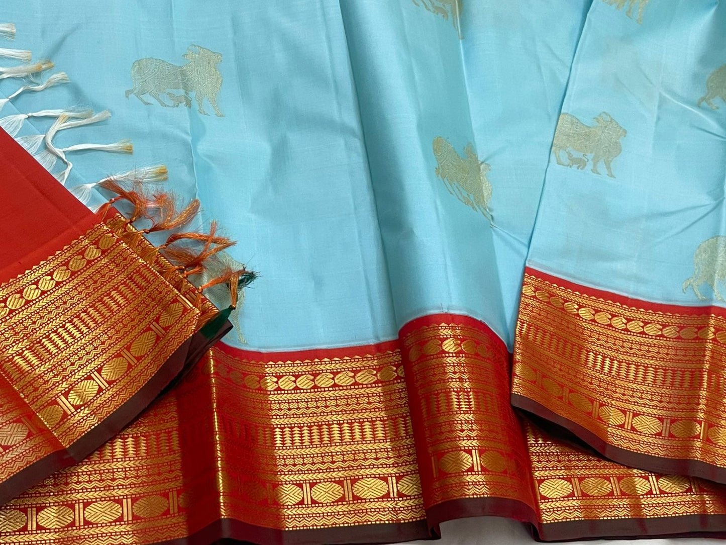 Kamadhenu — Pure Silk Kanchipuram
Sky-blue body with gold Kamadhenu motifs, fiery-orange pallu & ruby-red korvai borders ✨
Silk Mark Certified • Antique Zari Weave • Ships in Two Weeks • Free Shipping within USA