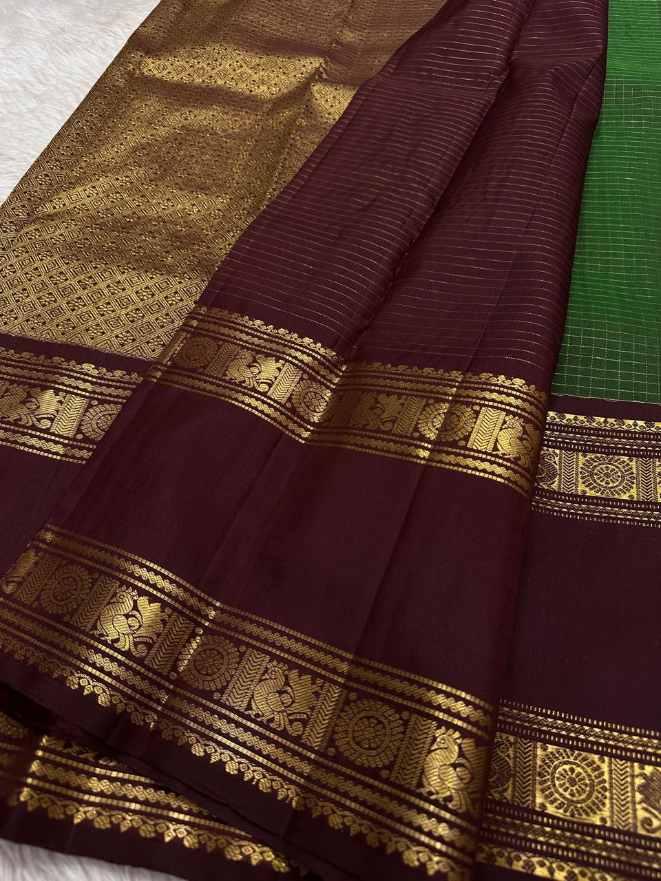 Geetham ✨
Forest Green Zari Kattam Pure Silk Kanchipuram Saree 🌿
With Ornate Rettapet Border of Peacock & Kamalam Motifs 🦚🌸
Flanked by Muthuseer Florals & Vanki Neli Columns 🌺
Finished with a Grand Brocade Maroon Pallu in Rich Zari ✨