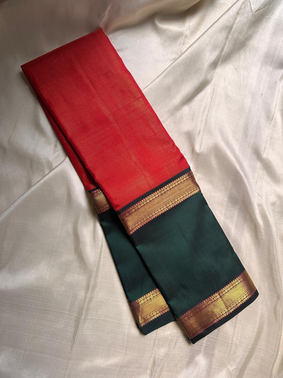A festive radiant orange silk saree with a rich vairaoosi all over bottle green border, woven to celebrate tradition with a bold flair.