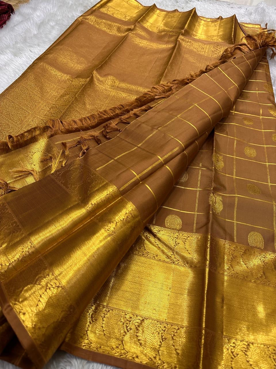 Bronze Chakram — Kanchipuram Pure Silk
Warm caramel-brown body with grid checks & “chakram” buttas
Grand gold zari peacock border & glowing pallu (kaddi + paisley vine)
Silk Mark Certified | Free Shipping within USA
Dispatch in 1 Week