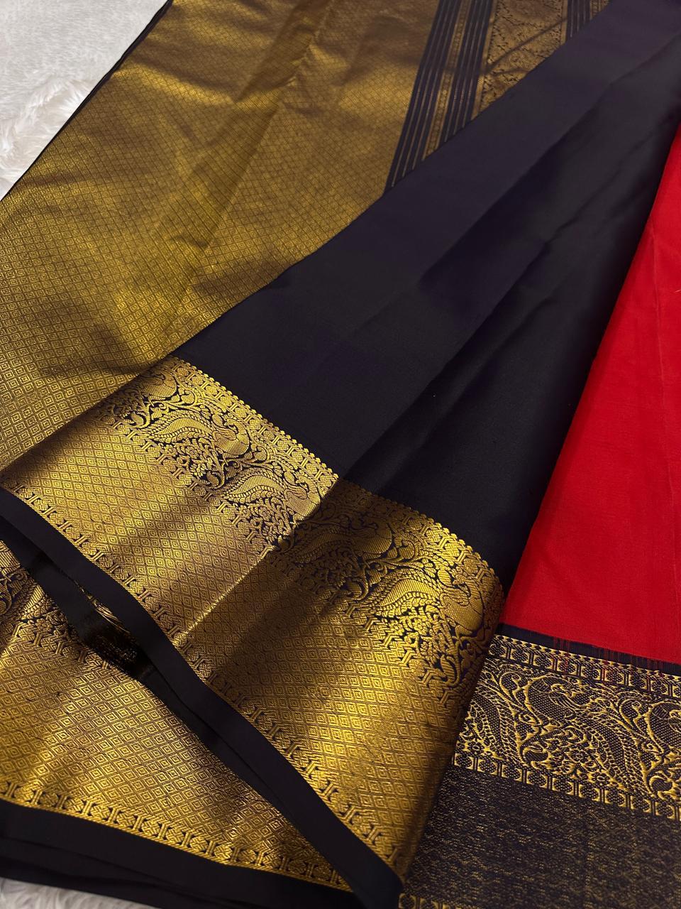Ranga - A vivid red pure silk Kanchipuram saree featuring intricate zari kattam with traditional mayil, chakram, butta, and vanasringaram motifs across the body. The contrast jamun dark blue border and pallu are woven with exquisite Annam motifs