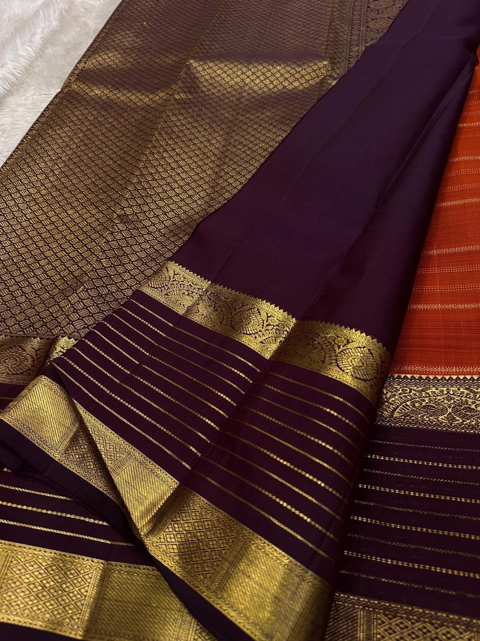 Cinnamon Kattam – Pure Kanchipuram Silk Saree
Vermillion red body with gold kattam checks & floral buttas
Contrast plum purple korvai borders with rich zari weave
Grand zari pallu with lattice & floral motifs in gold
Silk Mark Certified ships in 2weeks
