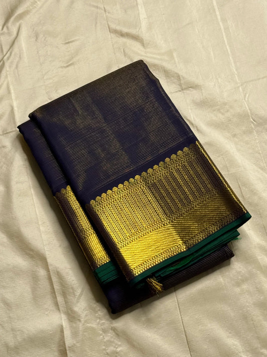 Krishna Shyama — Pure Silk Kanchipuram
Deepest purple “Shyama” body with Vairaoosi pinstripes
Temple-inspired antique gold zari borders with green selvedge
Grand striped zari pallu with hand-tied tassels
Silk Mark Certified • free shipping