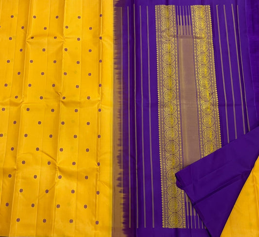 Manjal Vadamalli Chakram – Pure Kanchipuram Silk Saree
Marigold yellow body with purple floral thread buttas
Grand royal purple pallu with gold medallion zari & reku-style stripes
Handwoven Double Warp Weave | Silk Mark Certified | Fall & Pico Done