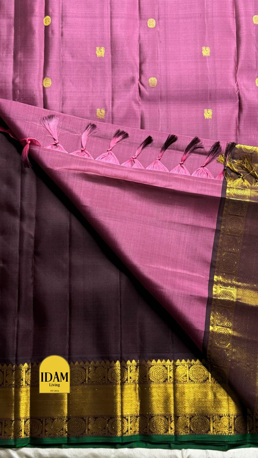 Tanaya features a regal mulberry mauve purple body adorned with golden kamalam and mayil buttas. Its elegant dual-tone border—coffee brown on top and emerald green below with rich temple-inspired zari work with medallions and florals woven, rich Pallu.