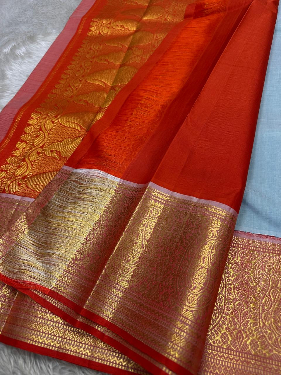 A saree where sky blue melts into sunrise orange—pure silk Kanchipuram magic.