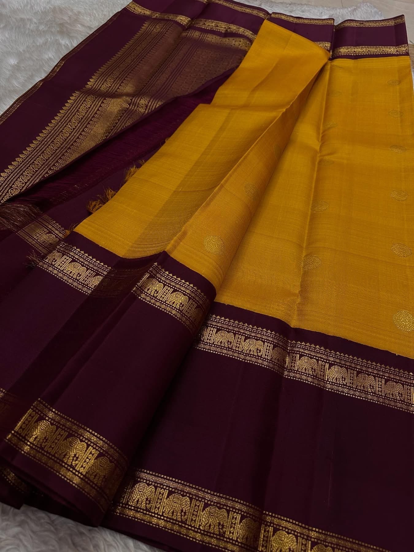 Bhanu – Mustard Gold Handwoven Kanchipuram Silk Saree with Deep Coffee Brown Borders, Intricate Elephant Motif Zari, and a Grand Temple-Inspired Pallu