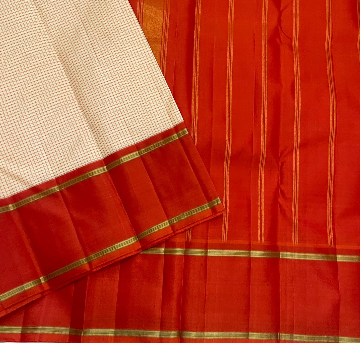 Ivory Vermillion Kattam — Pure Silk Kanchipuram Saree
Buttermilk-Ivory Body with Red Micro-Checks & Vermilion Korvai Border ✨
Gold Pin Lines, Leaf-Green Highlights & Rust Pallu • Silk Mark Certified • Ships in 1 Week ✅
