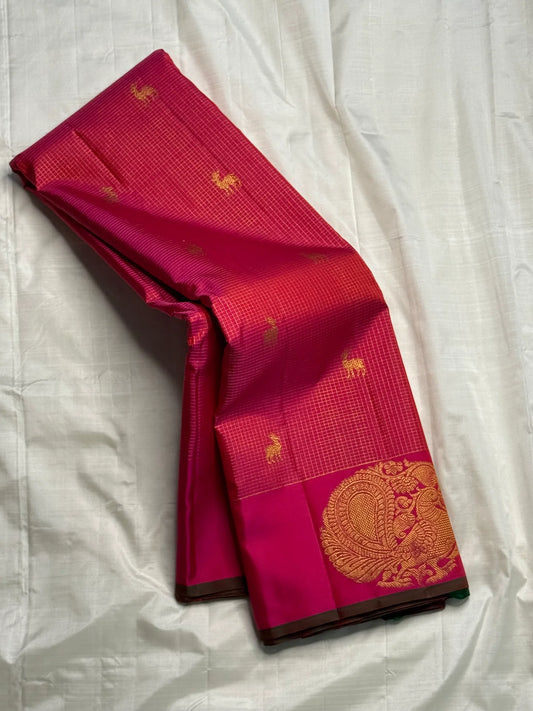 Peacock Arch Zari Kattam — Pure Silk Kanchipuram Saree
Magenta–Rani pink body with fine zari kattam checks & gold peacock motifs • Rust-orange brocade pallu with grand zari weave • Contrast selvedge & rich korvai borders
✨ Silk Mark Cert • Fall & Pico ✅