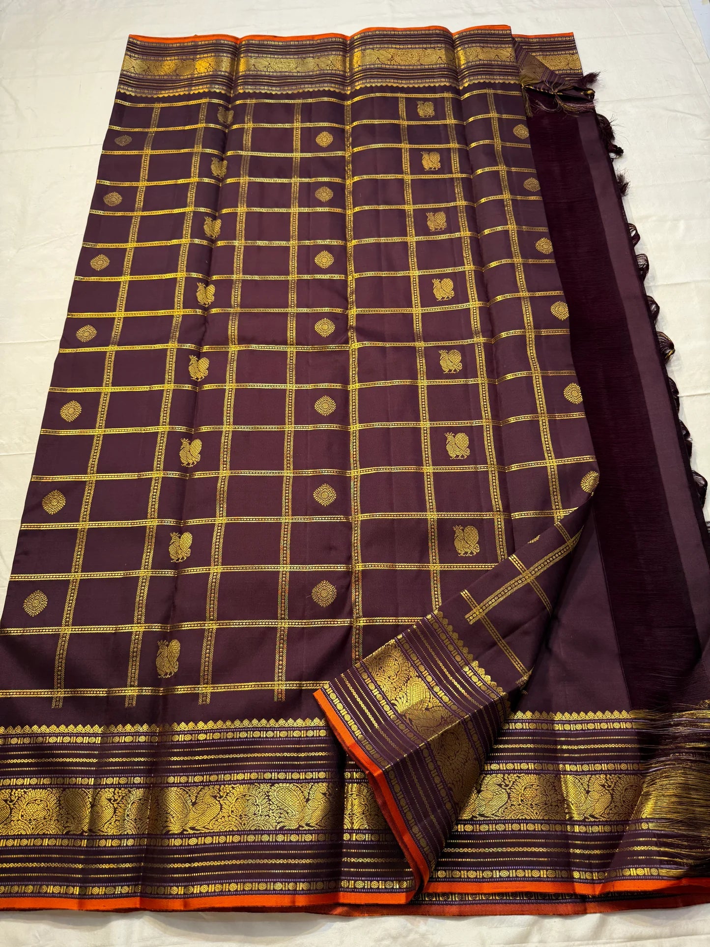 Then Thuli — Pure Silk Kanchipuram Saree
Coffee plum with gold kattam checks & mango buttas
Antique-gold peacock borders, brocade pallu, tasselled finish
Silk Mark Certified ✅ • Ships in Two Weeks ✅ • Free USA Shipping ✅