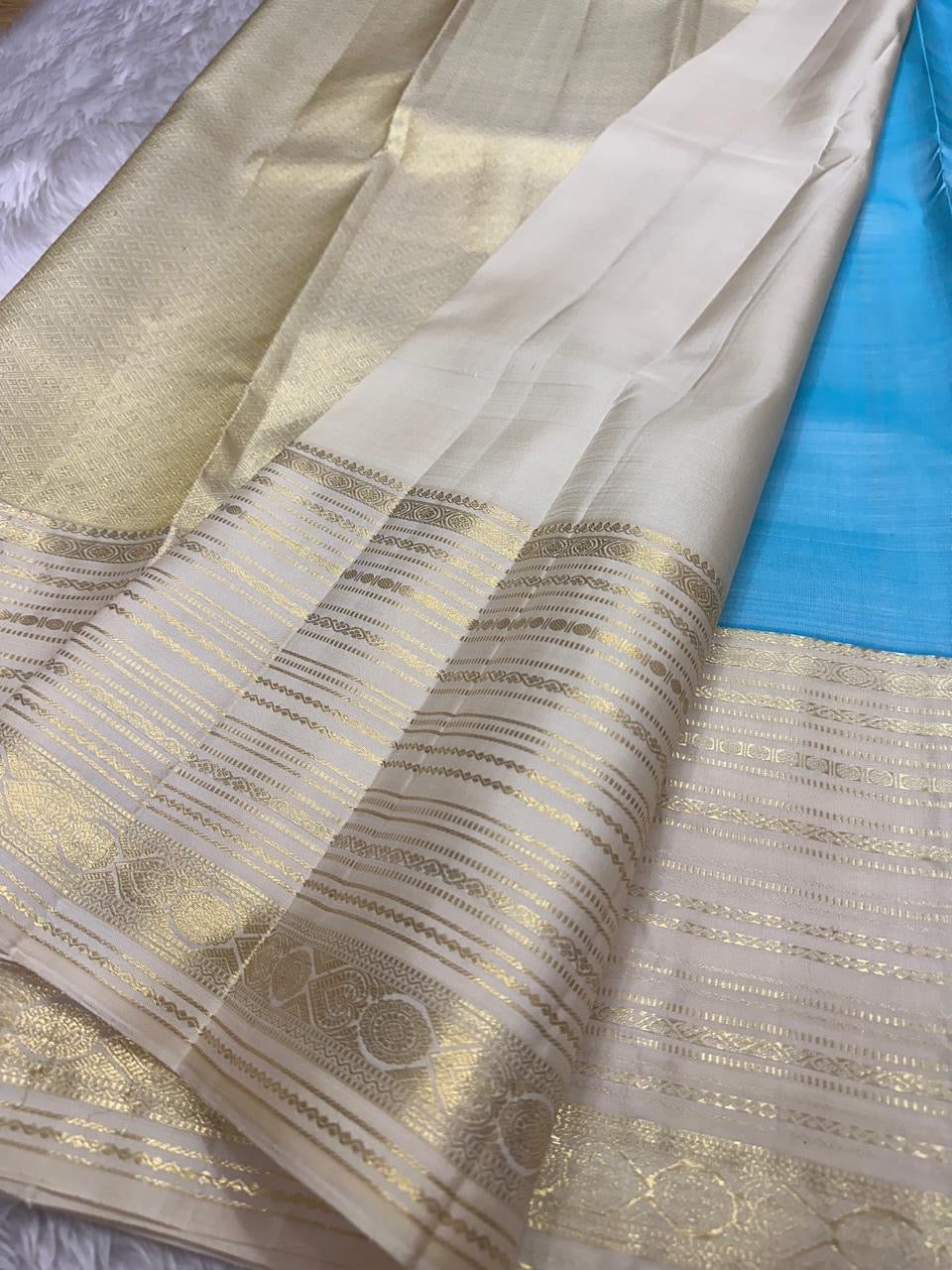 Blue Vennila Varisai – Pure Kanchipuram Silk Saree
Blue body with gold leaf buttas; contrast ivory varisai borders
Grand ivory pallu with rich zari stripes; contrast ivory blouse
Silk Mark Certified | Blouse Piece Included | Fall & Pico Done
Free Shipping