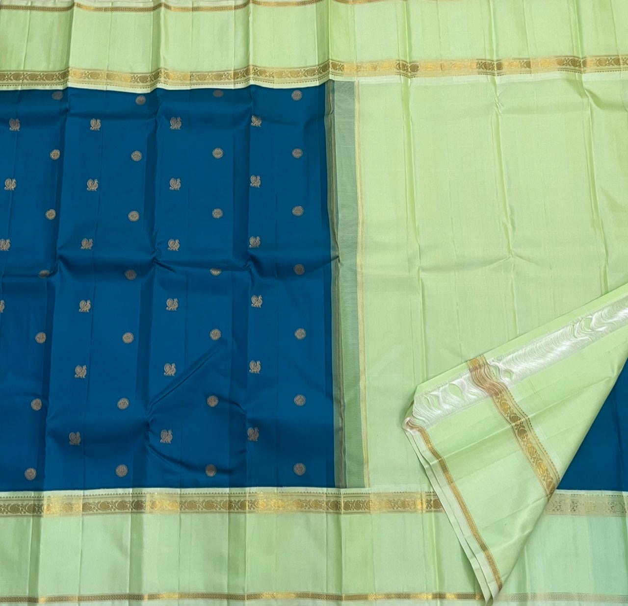 Vasantha Neelam — Teal Korvai Kanchipuram Pure Silk Saree
Peacock-blue body with gold muthu buttas · Mint-pistachio korvai border & pallū
Handloom Kanchipuram • Contrast running blouse included
Silk Mark Certified
Free Shipping within USA, 2 weeks