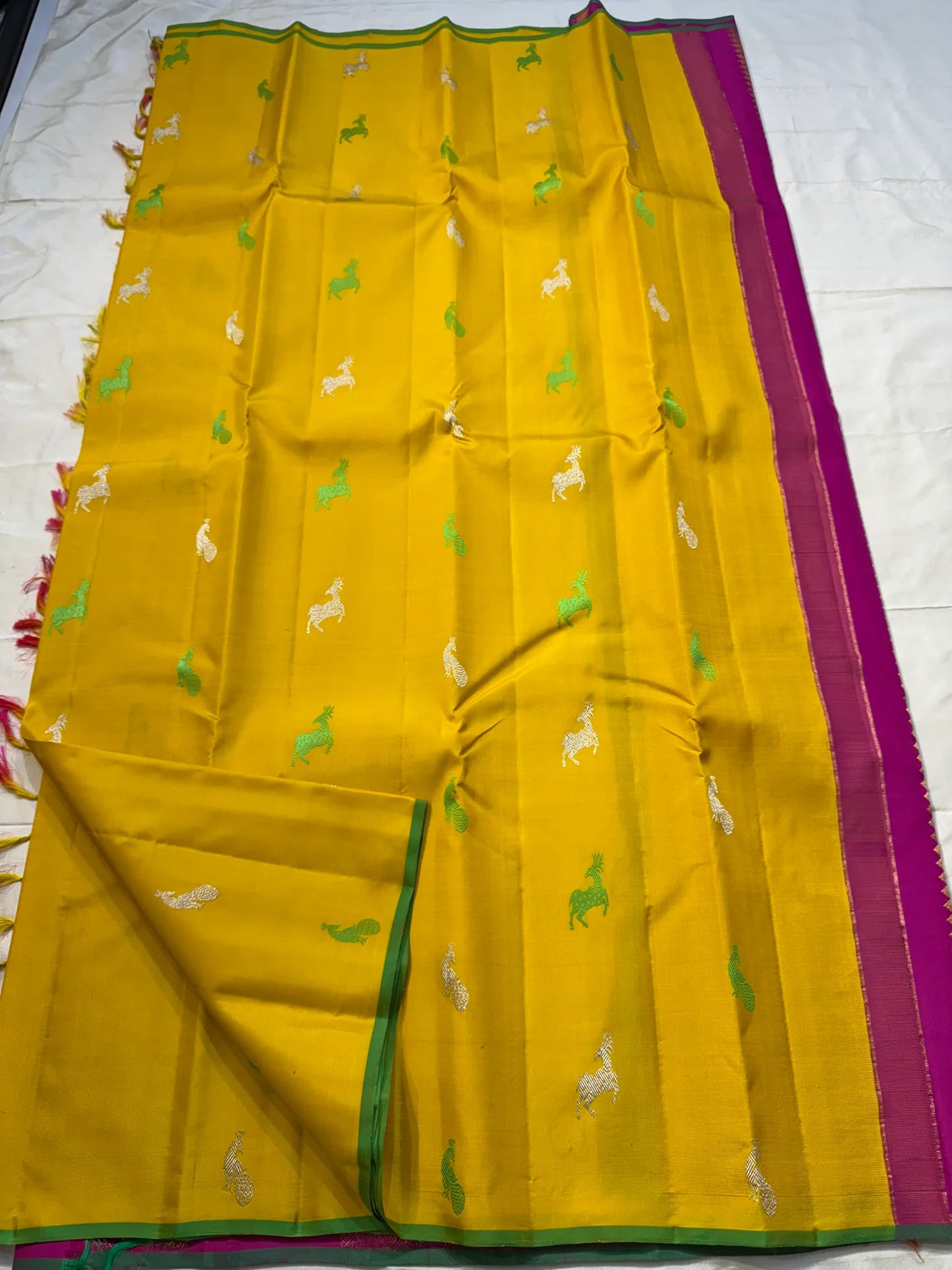 Silk Thread Deer Butta — Muted Yellow Pure Silk Kanchipuram Saree
Turmeric-yellow body with silver & parrot-green silk deer motifs · Rani-pink zari pallu with temple motifs · Green selvedge korvai border finish ✨
Silk Mark Certified ✅ | Fall & Pico Done ✅