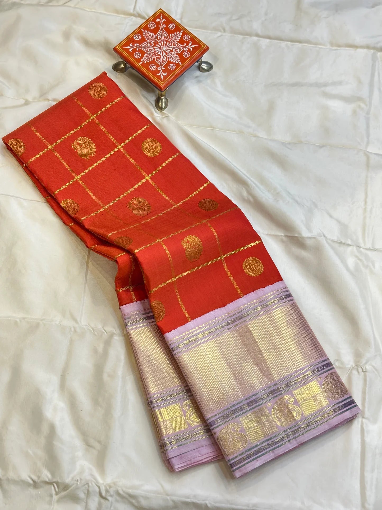 Bhargavi
Striking Orange Kanchipuram Silk Saree with Unusual Lavender Border 💜
Zari Kattam Neli Checks with Kamalam & Mayil Motifs Across the Body 🪷🦚
Broad Arai Maadam Border Flanked by Diamond & Paisley Motifs, Grand Zari Pallu ✨