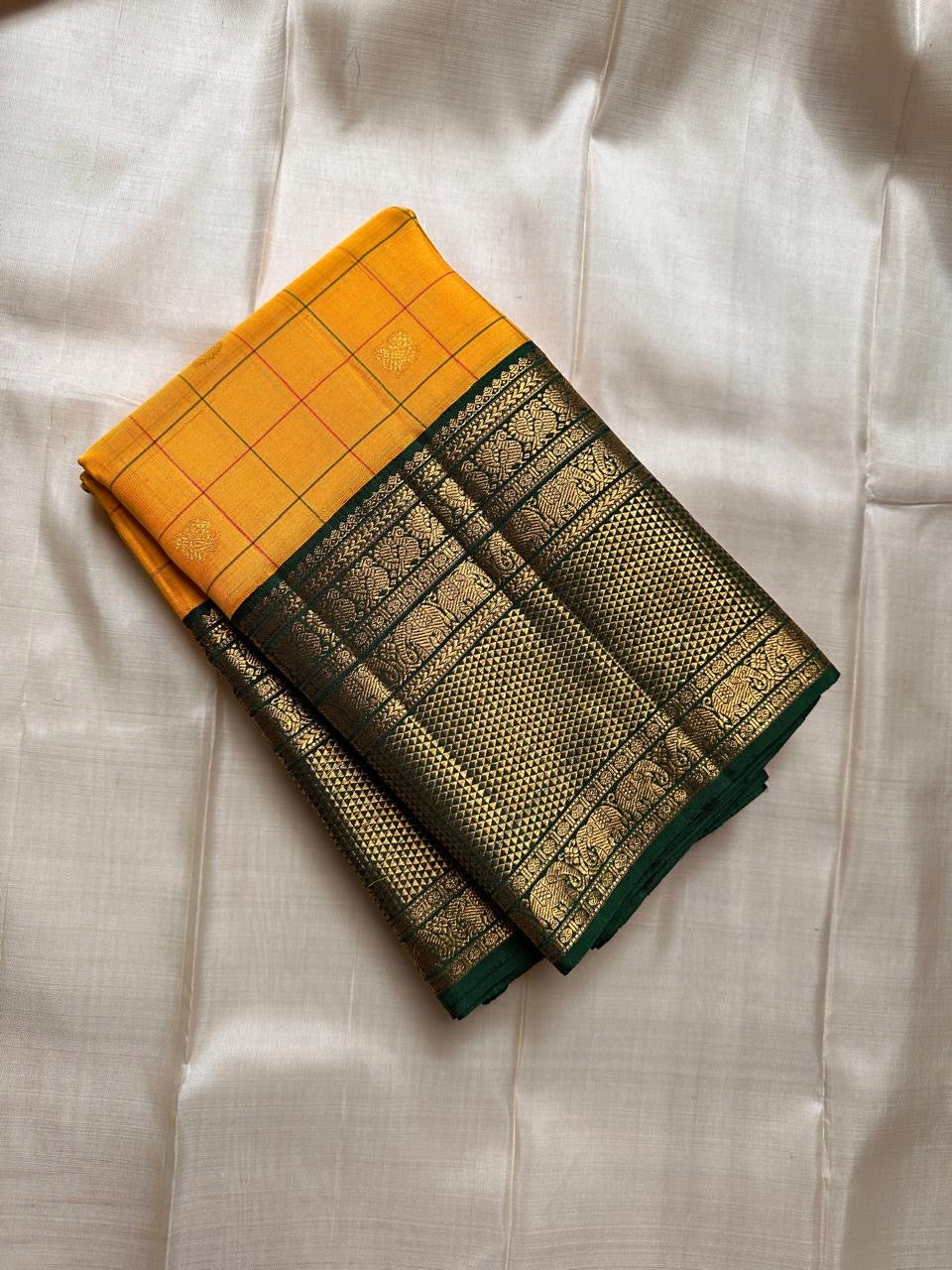 Manjal Pachai Kattam
Pure Kanchipuram Silk Saree – Marigold Yellow Body with Green Checks & Petite Zari Buttas
Deep Green Korvai Borders with Rich Gold Zari Weave & Traditional Elephant Motifs
Silk mark certified , ships in 2 weeks