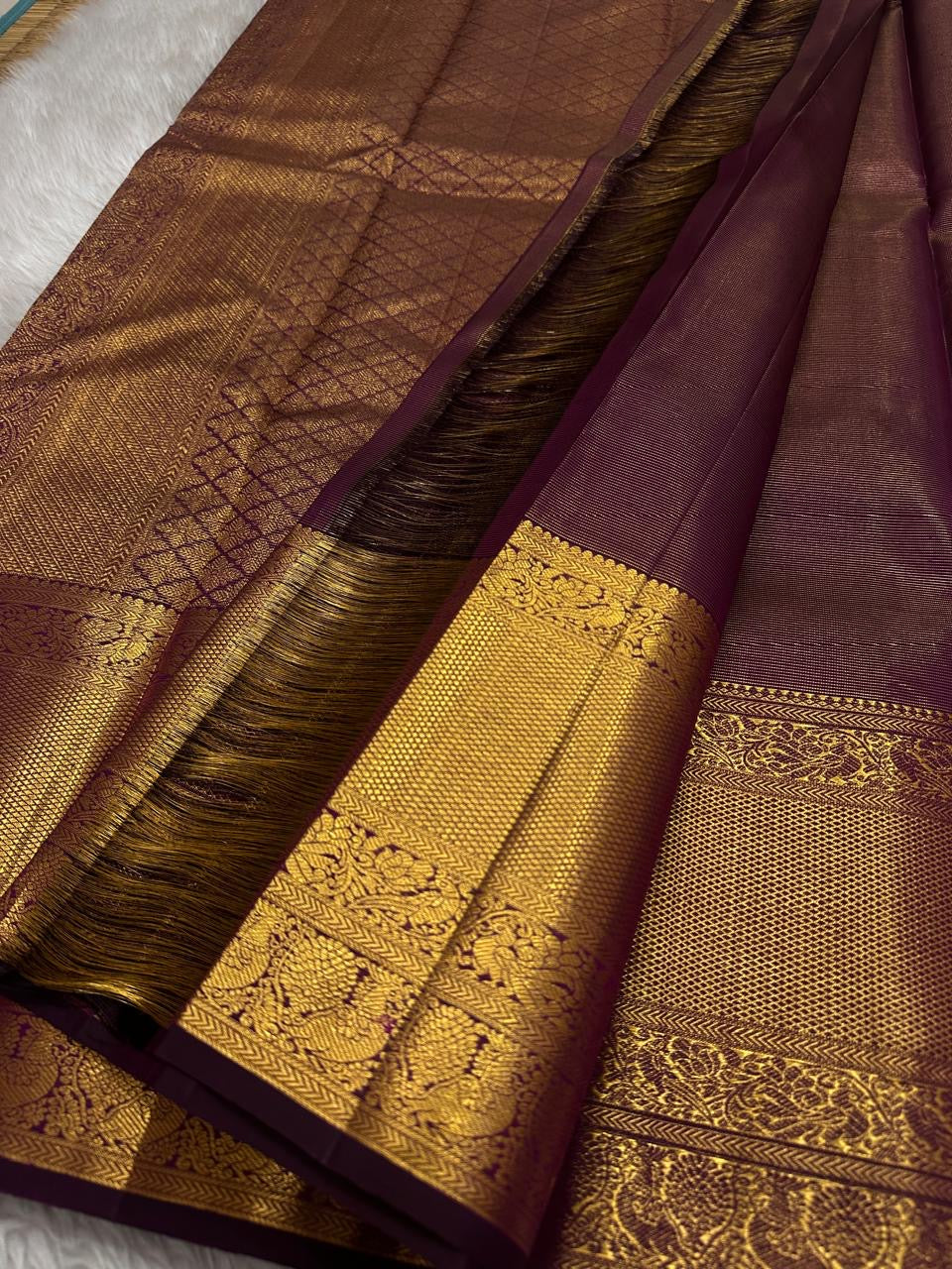 Varnika – Handwoven Kanchipuram Silk Saree in Plum Wine
A regal plum Kanchipuram silk saree adorned with gold zari paisleys and Gandaberunda motifs
