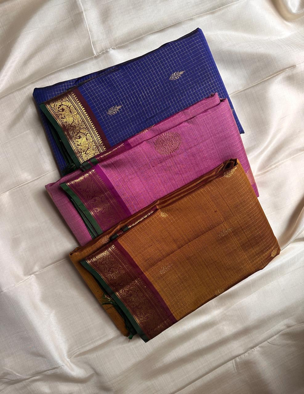 Amber Oosikattam ✨ – Pure Kanchipuram Silk Saree
Burnished Amber-Gold Body in Oosi Zari Kattam with Leaf Buttas
Deep Maroon Korvai Border with Green Selvedge & Elephant Motifs
Regal Maroon Pallu with Intricate Gold Zari Brocade
Silk Mark Certified |