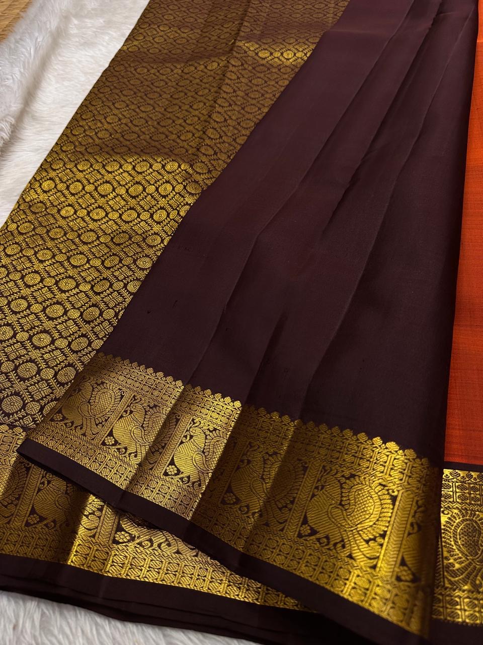 Rust Orange Paisley — Pure Silk Kanchipuram Saree
Rust-orange body with gold coin buttas & grand paisley motif, deep coffee borders with peacock zari panels & temple edge.
Rich zari pallu, contrast blouse; Silk Mark Certified ✅ Free USA Shipping 🇺🇸 Ship