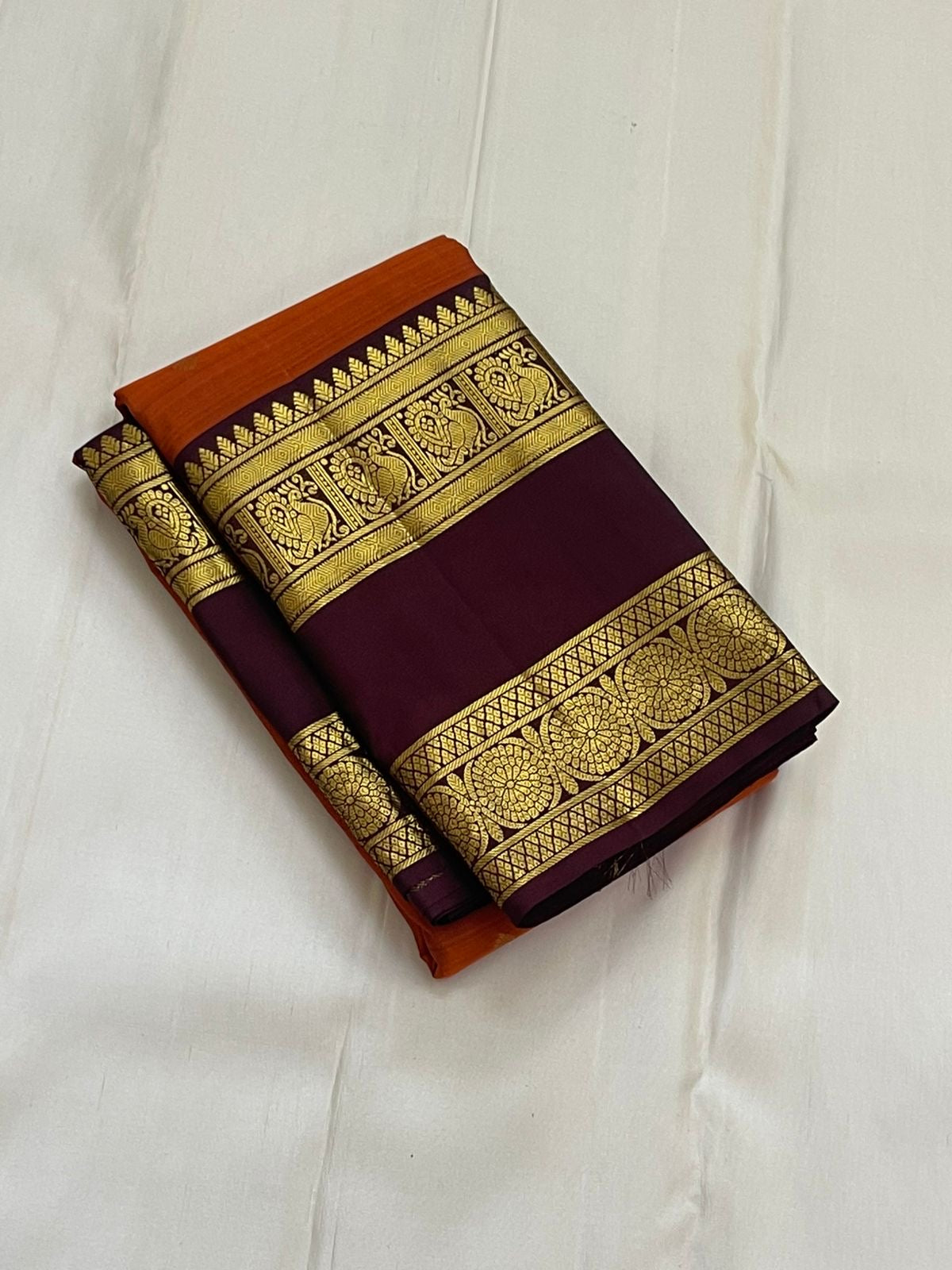 Rust Orange Ramyam – Pure Kanchipuram Silk Saree
Rust-orange body with pavin coin  buttas
Deep brown border with peacock panel & chakra medallions; grand zari pallu
Silk Mark Certified | Blouse Piece Included | Fall & Pico Done
Free Shipping in 1 week