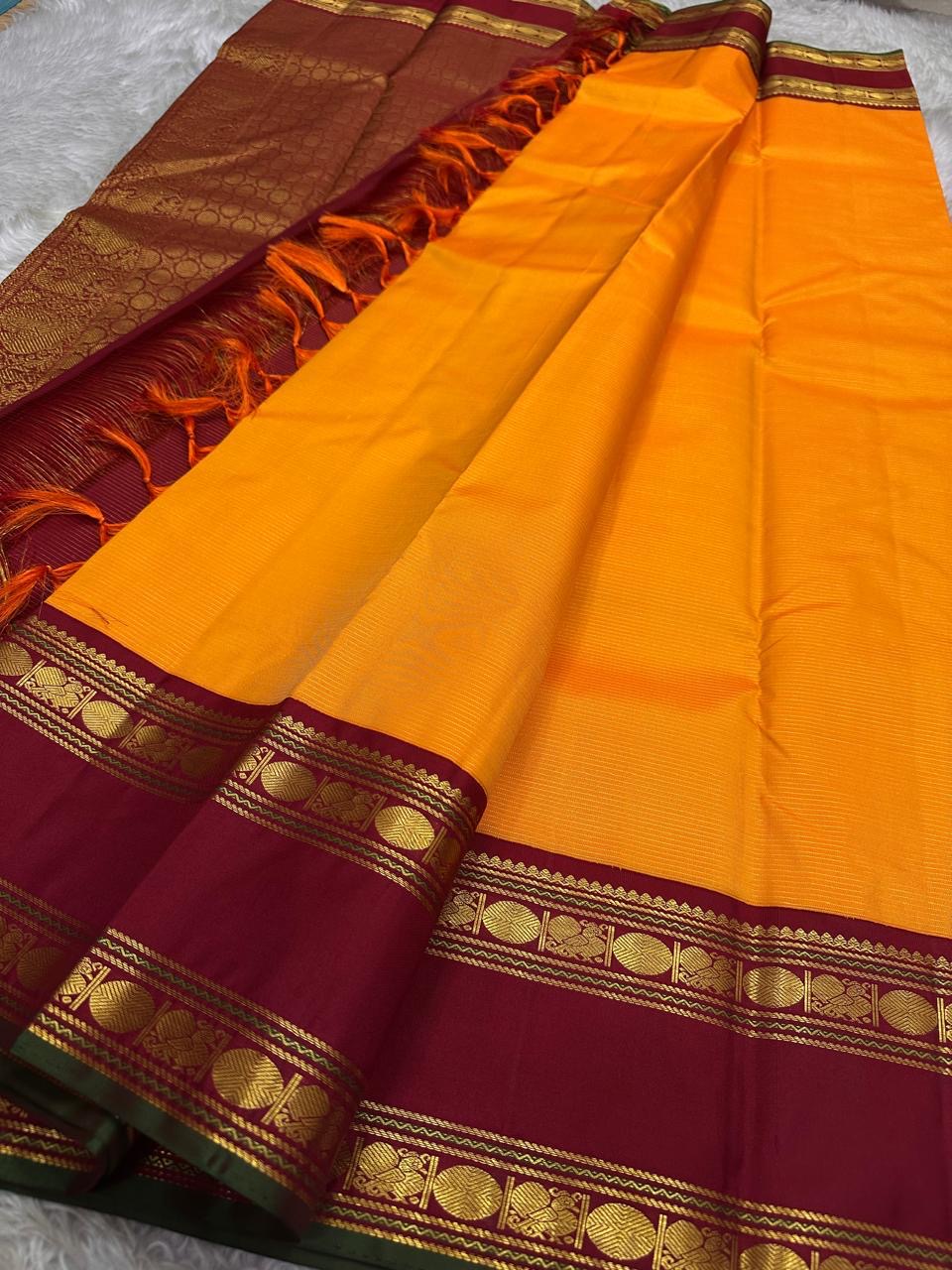 Vasantha Malli ✨ — Pure Silk Kanchipuram
Sunset-orange body with fine textured weave 🌸
Deep maroon borders with kasu zari & temple motifs ✨
Grand brocade pallu with traditional circular jaal 🪔 Perfect for Diwali & festive drapes
Silk Mark Certified • Fr