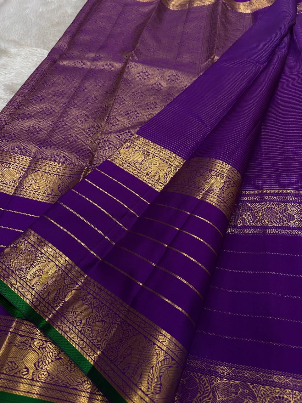 Kiran ✨ – Pure Kanchipuram Silk Saree
Regal Purple Body with Zari Kattam & Buttas
Classic Rettapet Border in Gold Zari Stripes
Intricate Heirloom-Inspired Zari Pallu
Accented with Contrast Green Selvedge Silk Mark Certified, delivery in 2 weeks