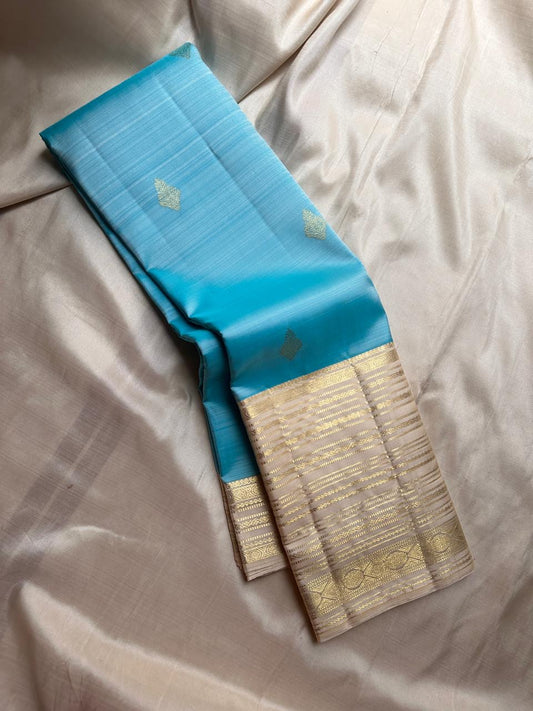 Blue Vennila Varisai – Pure Kanchipuram Silk Saree
Blue body with gold leaf buttas; contrast ivory varisai borders
Grand ivory pallu with rich zari stripes; contrast ivory blouse
Silk Mark Certified | Blouse Piece Included | Fall & Pico Done
Free Shipping