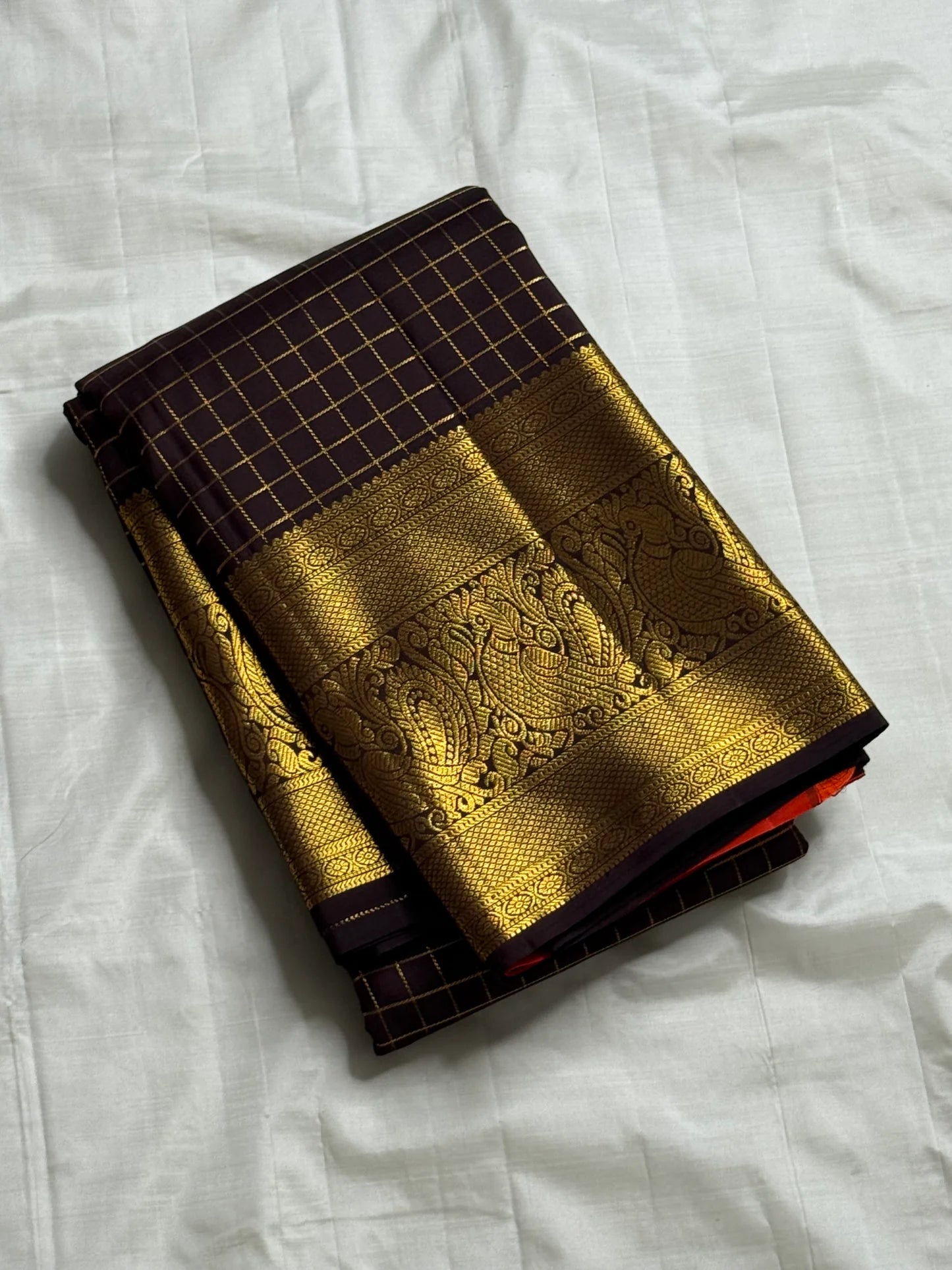 Mathura Layam — Pure Silk Kanchipuram Saree
Deep espresso brown with gold varisaipet checks & peacock zari border
Vermilion red vaira-kattam pallu | Silk Mark Certified | Ships in 2 Weeks | Free USA Shipping