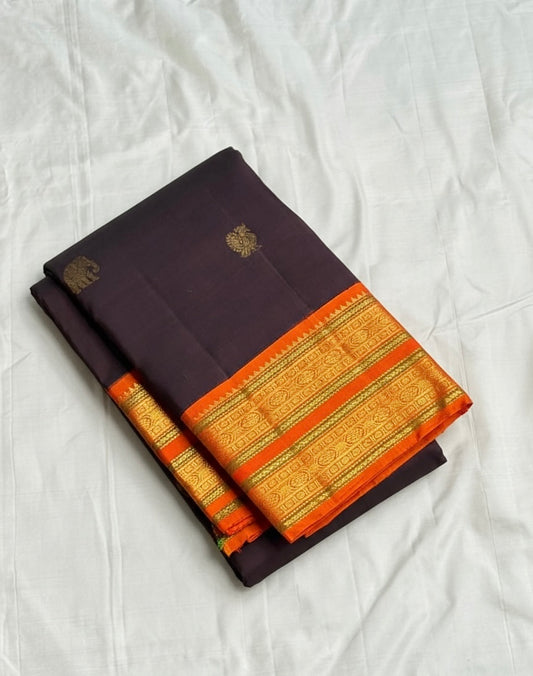 Deep Cocoa Manjari — Pure Kanchipuram Silk Saree
Rich cocoa-aubergine body with antique-gold manjari buttas, paired with a radiant kavi-orange korvai border and green selvedge accent.
Silk Mark Certified • Blouse Stitching Available ($30) • Free Shipping