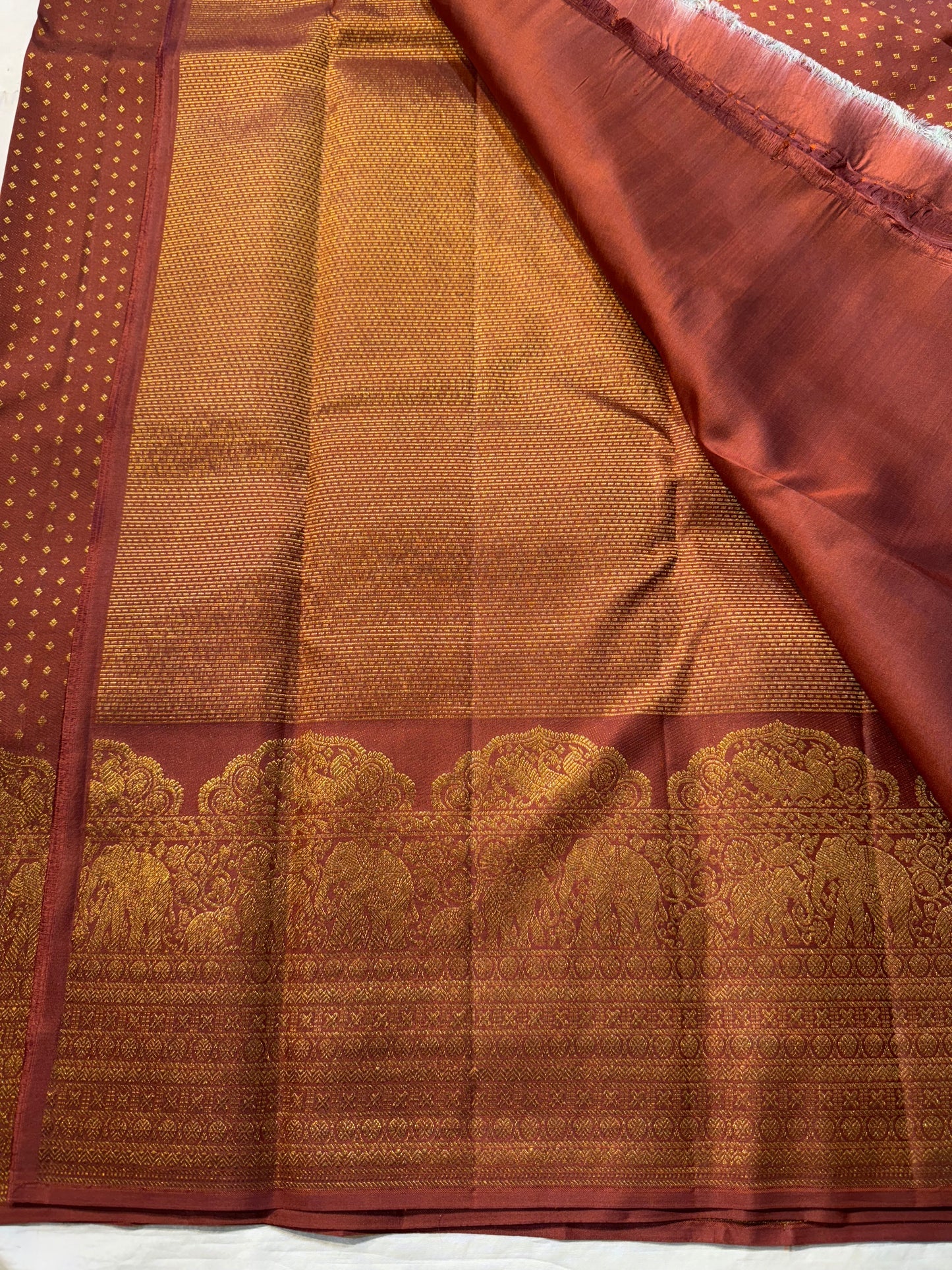 Rust Orange Elephant Peacock Arches – Pure Silk Kanchipuram Saree
Tiny gold podi butta motifs with grand elephant & peacock arch borders
Rich antique-gold zari pallu with floral columns & temple designs
Silk Mark Certified | Free Shipping within USA-