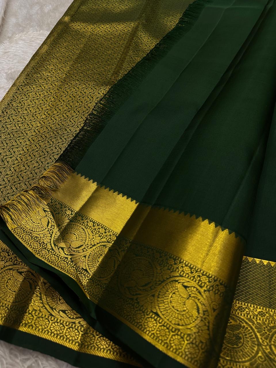 Agnika – Green Kanchipuram Silk Saree with Mayil Chakram Butta
Fiery and regal, Agnika features a rich green silk body with intricate Mayil Chakram (peacock) motifs and a shimmering zari border—an elegant ode to South Indian tradition.
