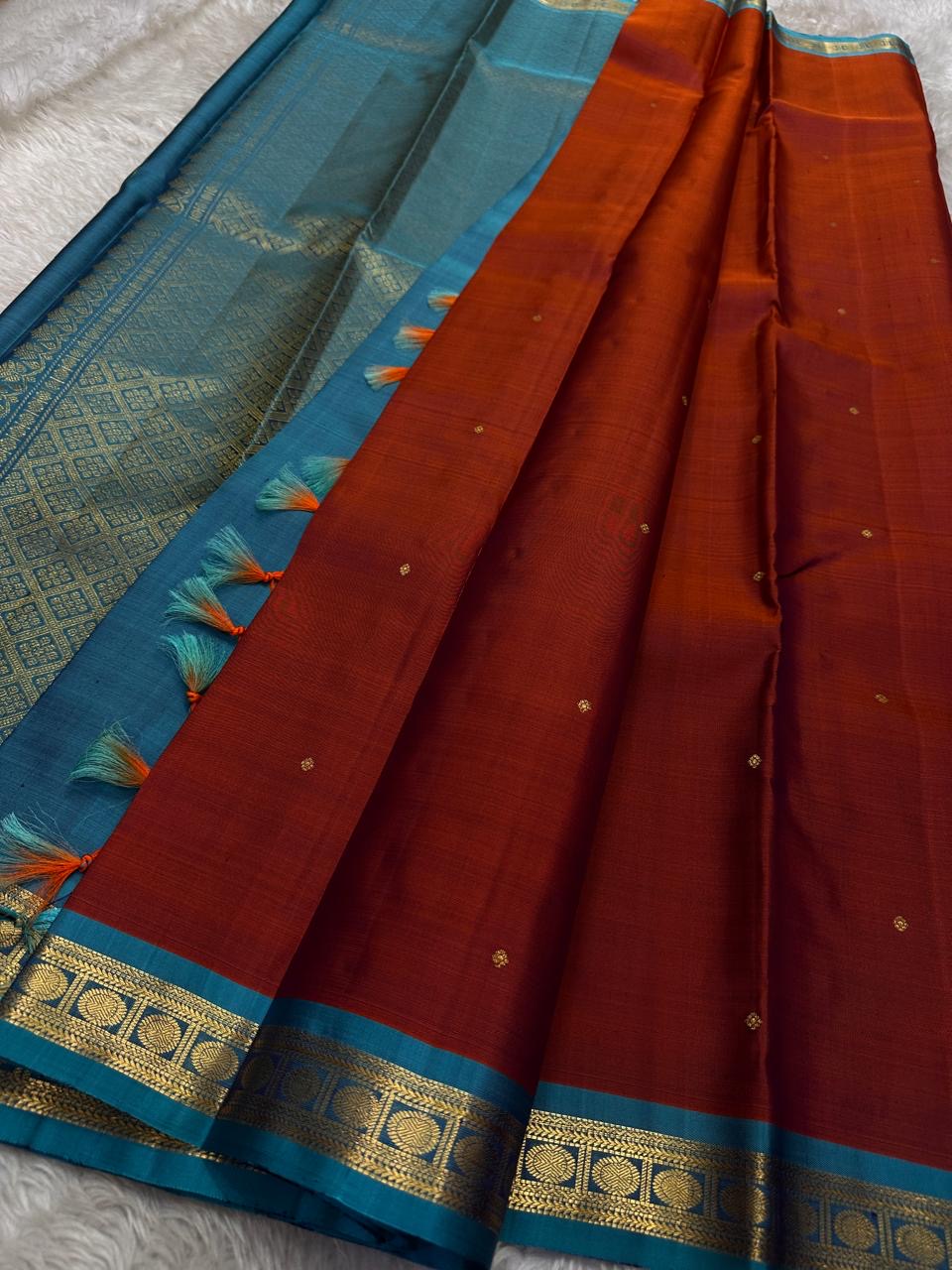 Komethagam Rama ✨
Pure Kanchipuram Silk Saree in Ember Red & Rāmar Blue
Ember-red body with gold zari buttas – gemstone inspired
Contrast Rāmar-blue border with chakra & vine motifs
Silk Mark Certified, delivery in 2 weeks