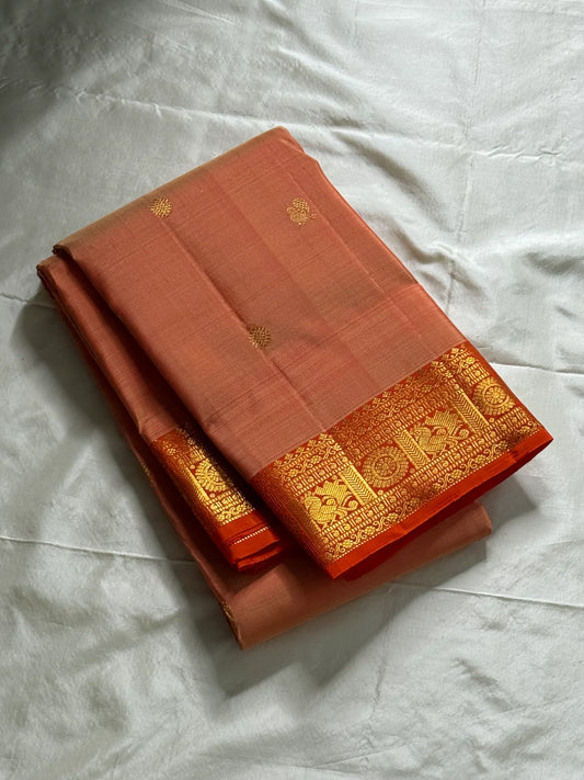 Mandara Peach – Pure Korvai Kanchipuram Silk Saree
Soft peach shot body with dainty gold chakram buttas
Vermilion-orange korvai borders with peacock medallions
Grand kumkumam red pallu with full zari brocade & temple panels
Silk Mark Certified | Free Ship