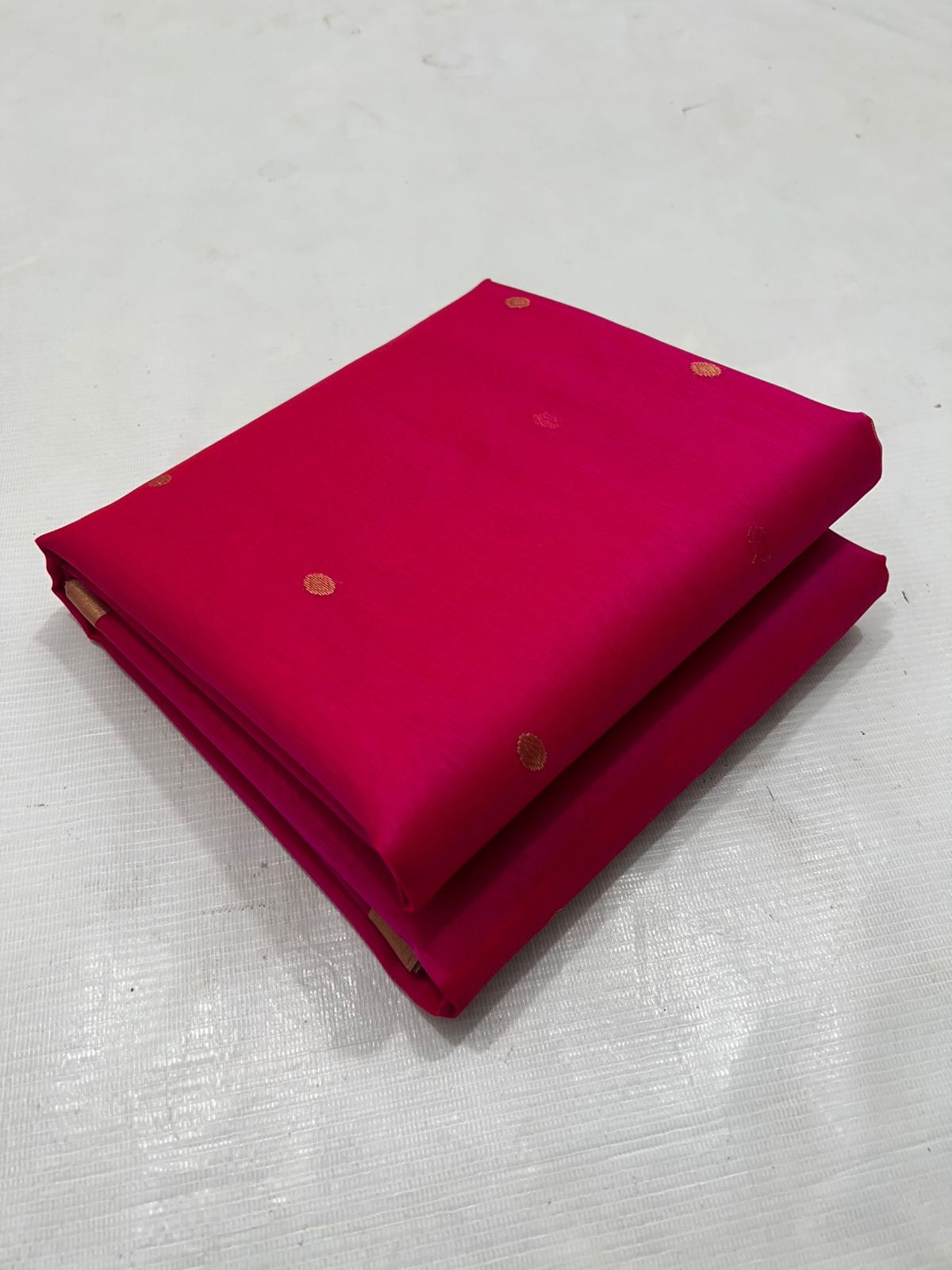 A timeless classic, this Rani pink Chanderi silk saree is a celebration of heritage and elegance. Crafted from lightweight silk with a luxurious sheen, the saree features all-over gold zari floral leafy buttas