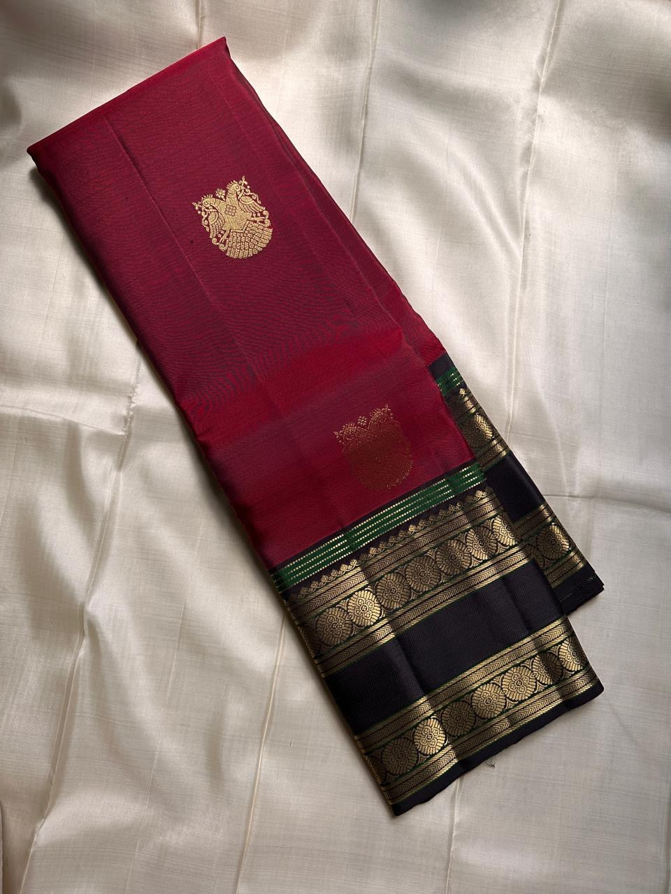 Ishwaryam ❤️🕊️✨
Ruby Red Handwoven Kanchipuram Silk Saree with Majestic Gandaberunda Zari Adai Motif 🕊️🌟
Ornate Rettapet Border with Delicate Kamalam Seer Floral Detailing 🌺🪡
Deep Coffee Brown Pallu Adding Warmth and Elegant Contrast ☕🌿