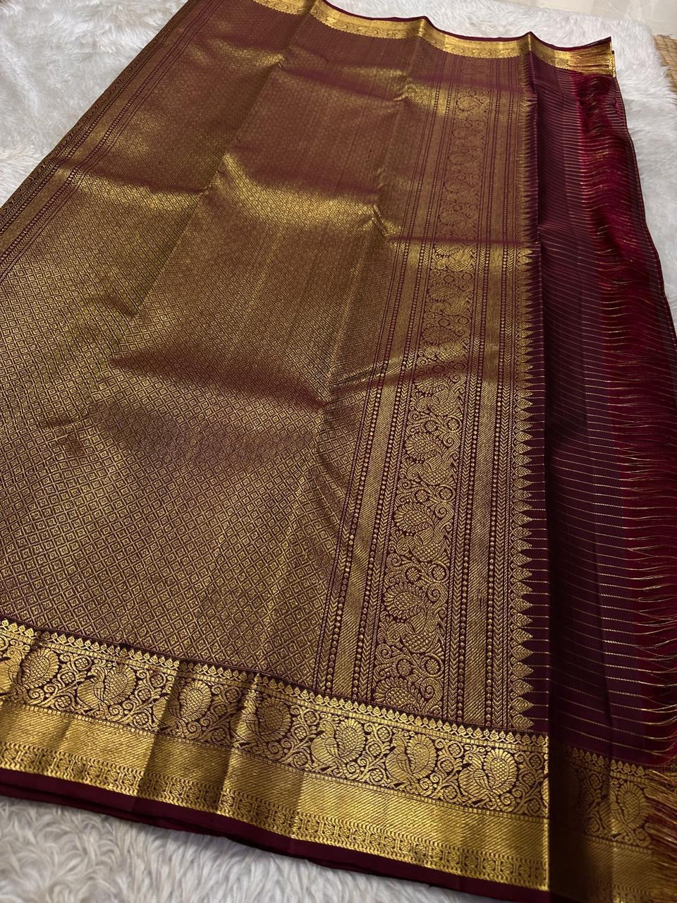 Zari Kattam Araimaadam – Coffee Brown, Pure Kanchipuram Silk Saree
Coffee-brown body with zari kattam checks, floral & mango buttas
Grand antique-gold border with floral/peacock vine;
Silk Mark Certified | Blouse Piece Included |ships in 1 week