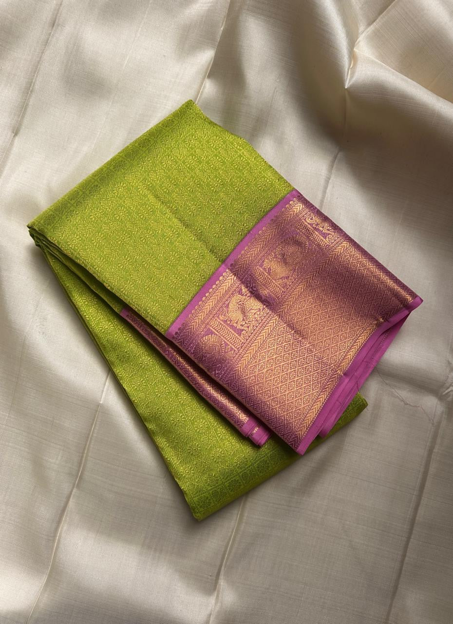 Harita – Chartreuse Green & Pastel Pink Kanchipuram Pure Silk Saree with Floral Jaal & Mayil Border
A refreshing chartreuse green drape with intricate silk thread floral jaal work.
Finished with pastel pink mayil borders and a thick woven Pallu