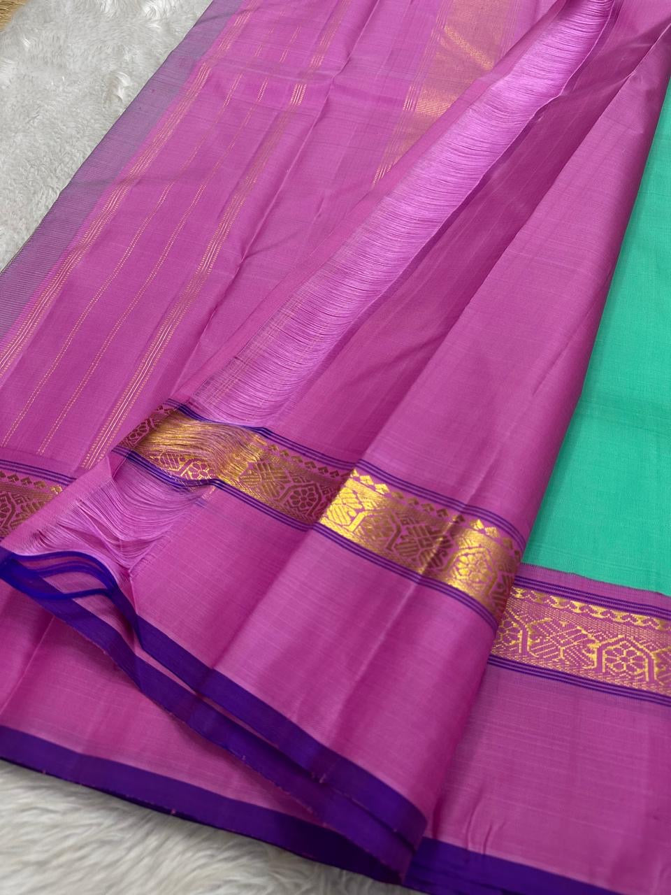 Jade Blossom – Pure Silk Kanchipuram Saree
Elegant Jade-Teal Body with Lustrous Weave 🌿
Rani-Magenta Contrast Border with Gold Zari ✨ purple selvedge
Grand Magenta Pallu in Lattice Design
Silk Mark Certified | ships in 2 weeks