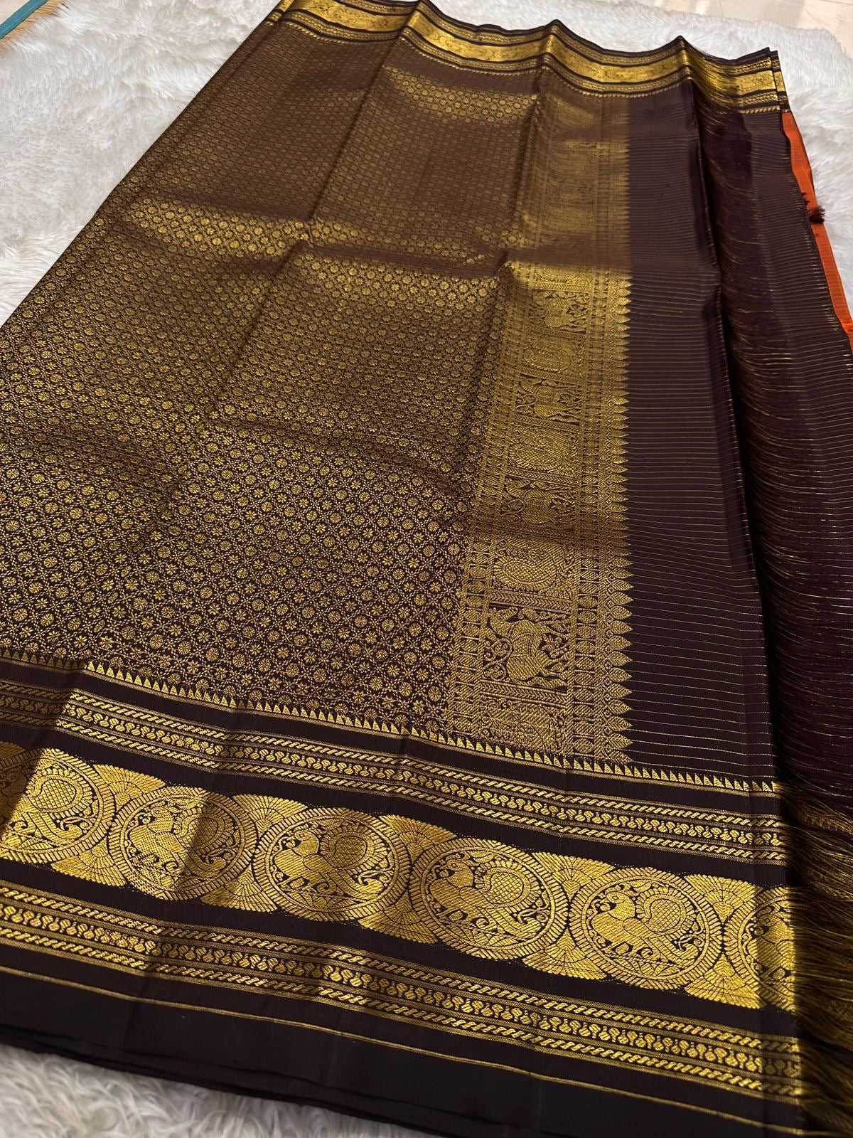 Diya Rust Orange – Pure Silk Kanchipuram
Rust-orange kattam checks with coin buttas ✨
Coffee-brown korvai borders with grand Annam medallions 🪔
Rich coffee-brown brocade pallu with zari stripe weave 🌿
Silk Mark Certified • Ships in Two Weeks • Free Ship