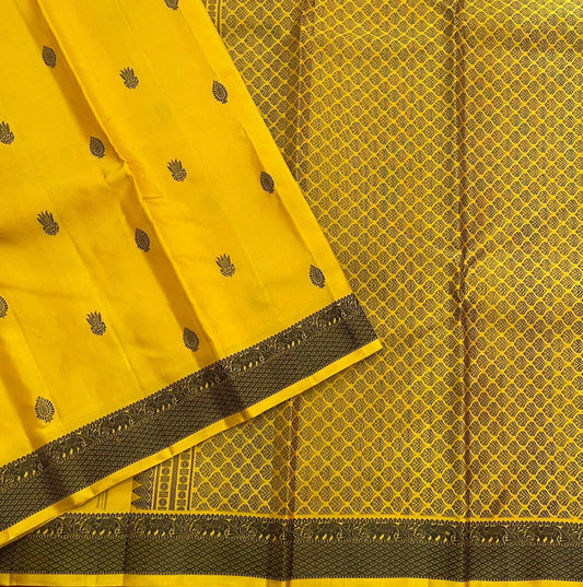 Marigold – Pure Kanchipuram Silk Saree
Haldi yellow body with charcoal paisley buttas
Contrast charcoal border in silk thread, floral vine
Silk Mark Certified | Blouse Piece Included | Fall & Pico Done
Free Shipping within USA | Ships in 2 Weeks