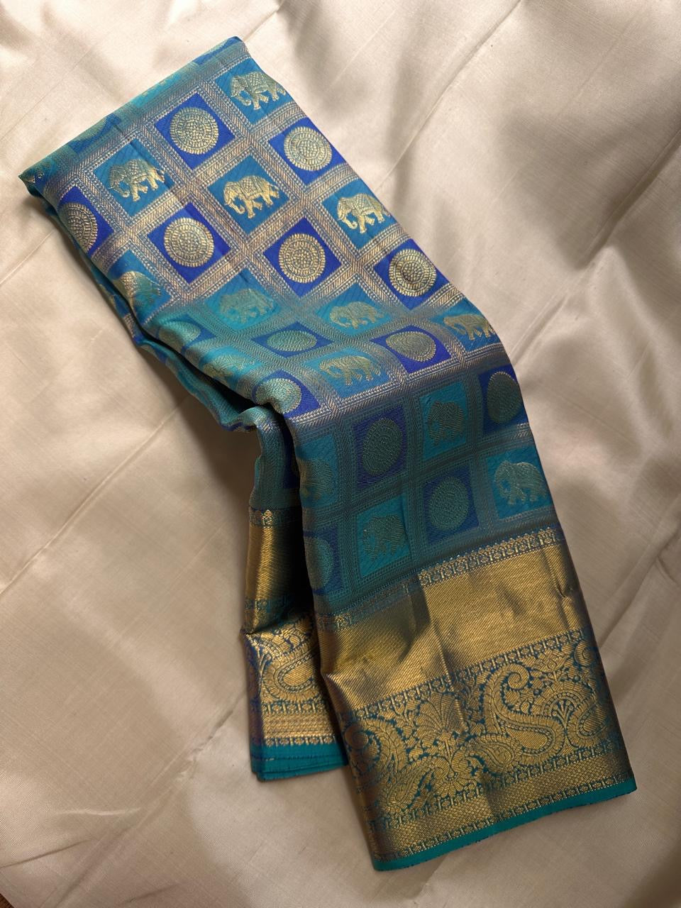 Pure silk KanchiPuram peacock blue with a shot of green elephant and Kamalam Zari checks saree