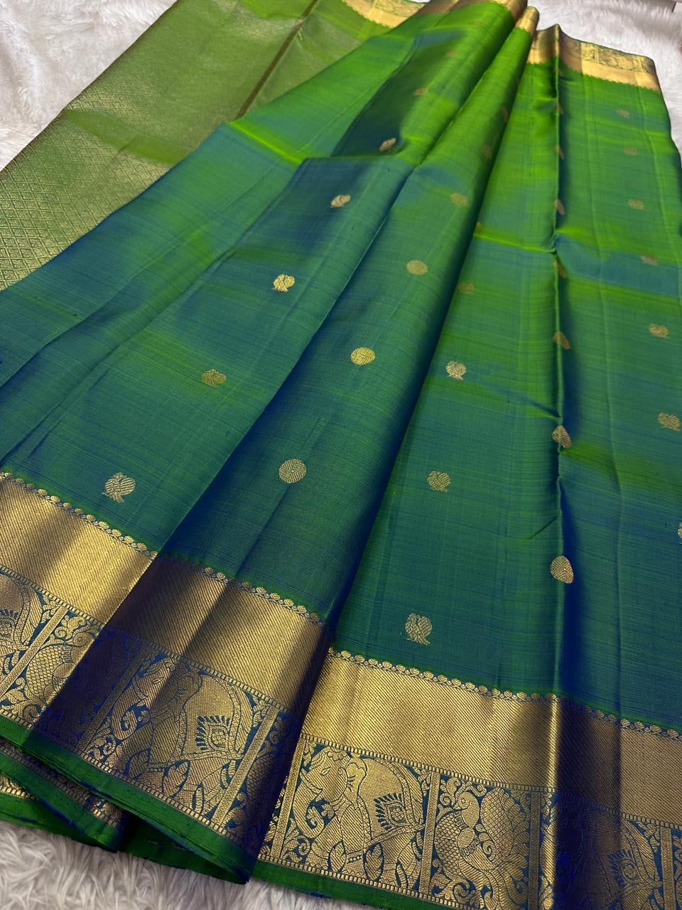 Dia ✨ – Vibrant Peacock Green Kanchipuram Pure Silk Saree
Gold Zari Buttas Adorning the Body
Intricate Gaja–Annam (Elephant & Peacock) Motif Border
Coordinated Peacock Green Silk Blouse Piece Included
Silk Mark Certified | Fall & Pico Done | Ready to Ship