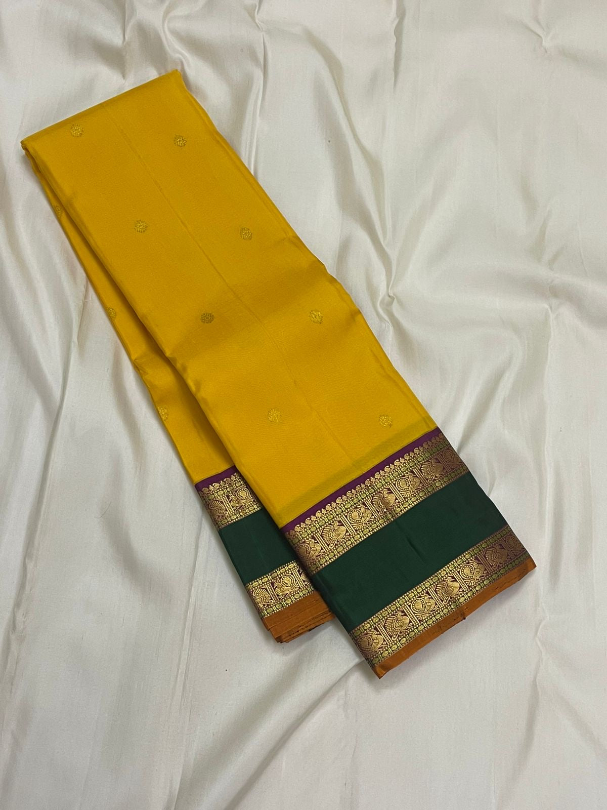 Amrita Pallavi — Kanchipuram Pure Silk
Marigold Yellow Body with Gold Zari Buttas ✨
Deep Bottle-Green Korvai Borders with Paisley Zari & Violet Selvedge
Regal Purple Pallu with Diamond Jaal and Leaf Columns 🌸
Silk Mark Certified | Free USA Shipping |