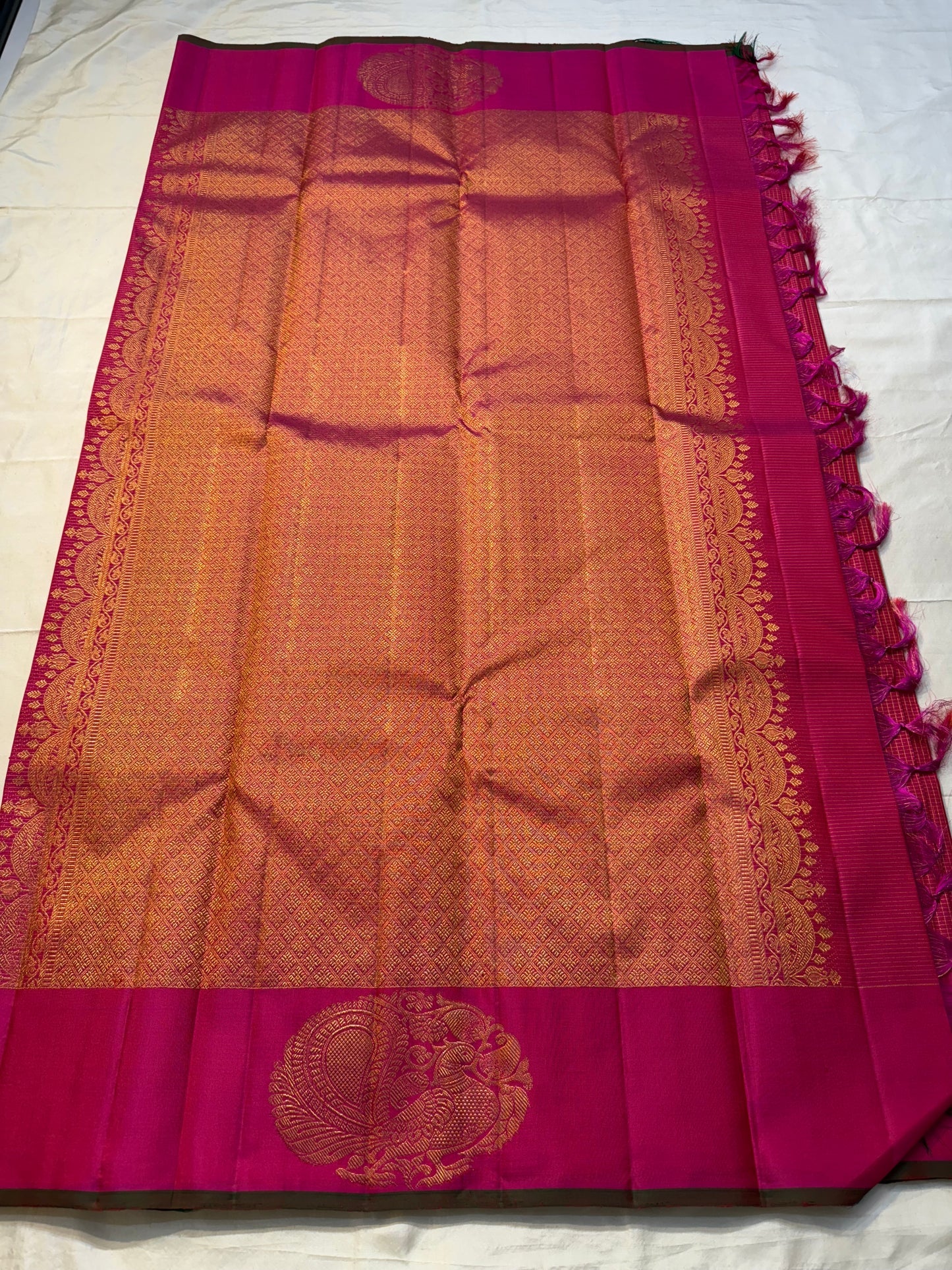 Peacock Arch Zari Kattam — Pure Silk Kanchipuram Saree
Magenta–Rani pink body with fine zari kattam checks & gold peacock motifs • Rust-orange brocade pallu with grand zari weave • Contrast selvedge & rich korvai borders
✨ Silk Mark Cert • Fall & Pico ✅