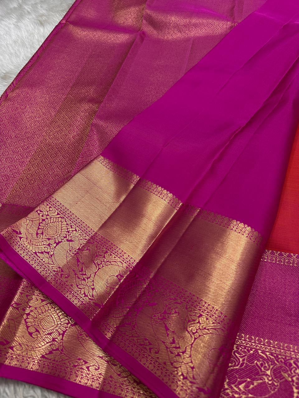 Sunset Peacock – Pure Kanchipuram Silk Saree
Sunset-Orange to Fuchsia Body with Zari Buttas ✨
Gold Zari Peacock Panel Border with Leafy Creeper Motif
Grand Fuchsia Brocade Pallu with Lattice Jaal Weave
Silk Mark Certified, delivery in 2 weeks