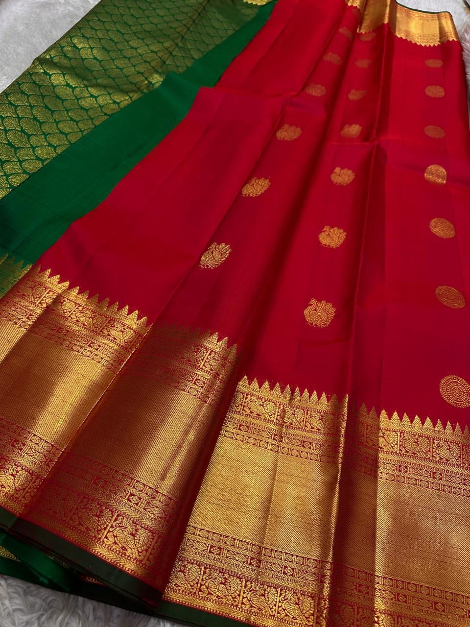 Srinagar Red Mayil Kamalam — Pure Silk Kanchipuram Saree
Temple-red body with gold mayil kamalam buttas ✨
Emerald-green korvai borders & grand gold pallu 💫
Silk Mark Certified ✅ • Free USA Shipping 🚚 • Ships in 2 Weeks