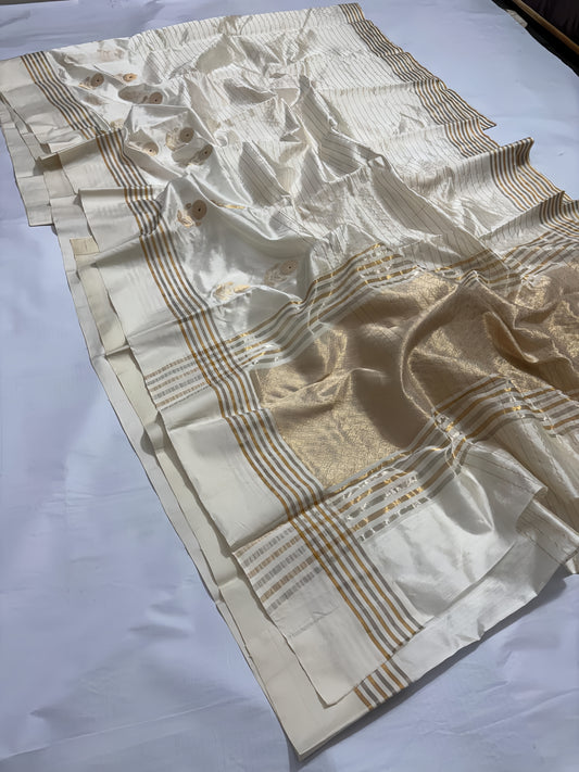 Ivory Cream Chanderi Saree with Gold Zari and Handwoven Sunflower Motifs.
A serene blend of tradition and elegance, with intricate red mina accents. Finished with alternating sona roopa stripes and a richly woven pallu for timeless festive charm