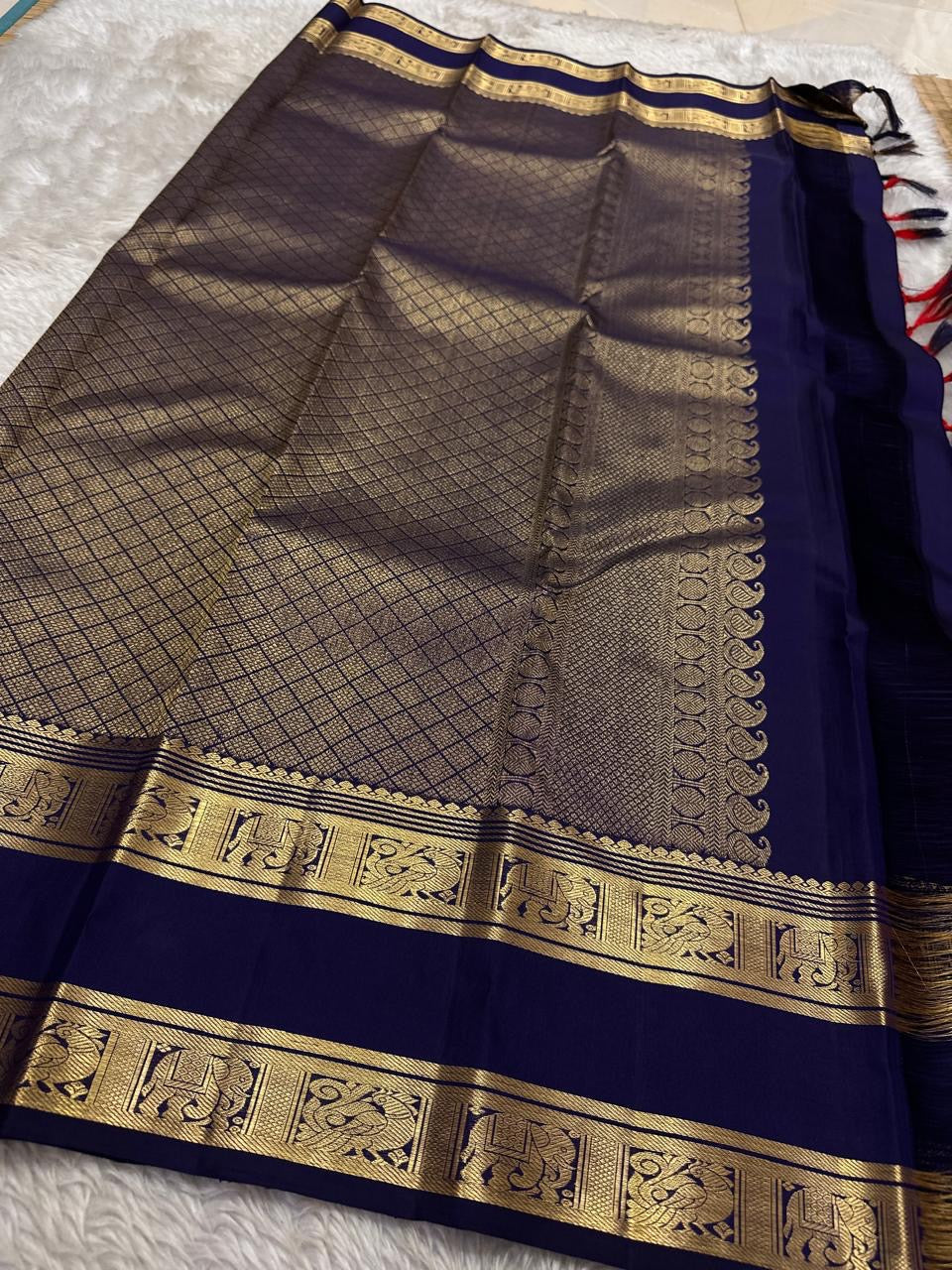 Anuraaga – Neelam
 — Pure Kanchipuram Silk
Vertical Pin-Stripe (Vairaoosi) Body • Gold Coin Buttas
Navy (Neelam) Korvai Border with Elephant Motifs
Diamond-Jaal Brocade Pallu • Running Contrast Blouse
Silk Mark Certified • free shipping in Two Weeks