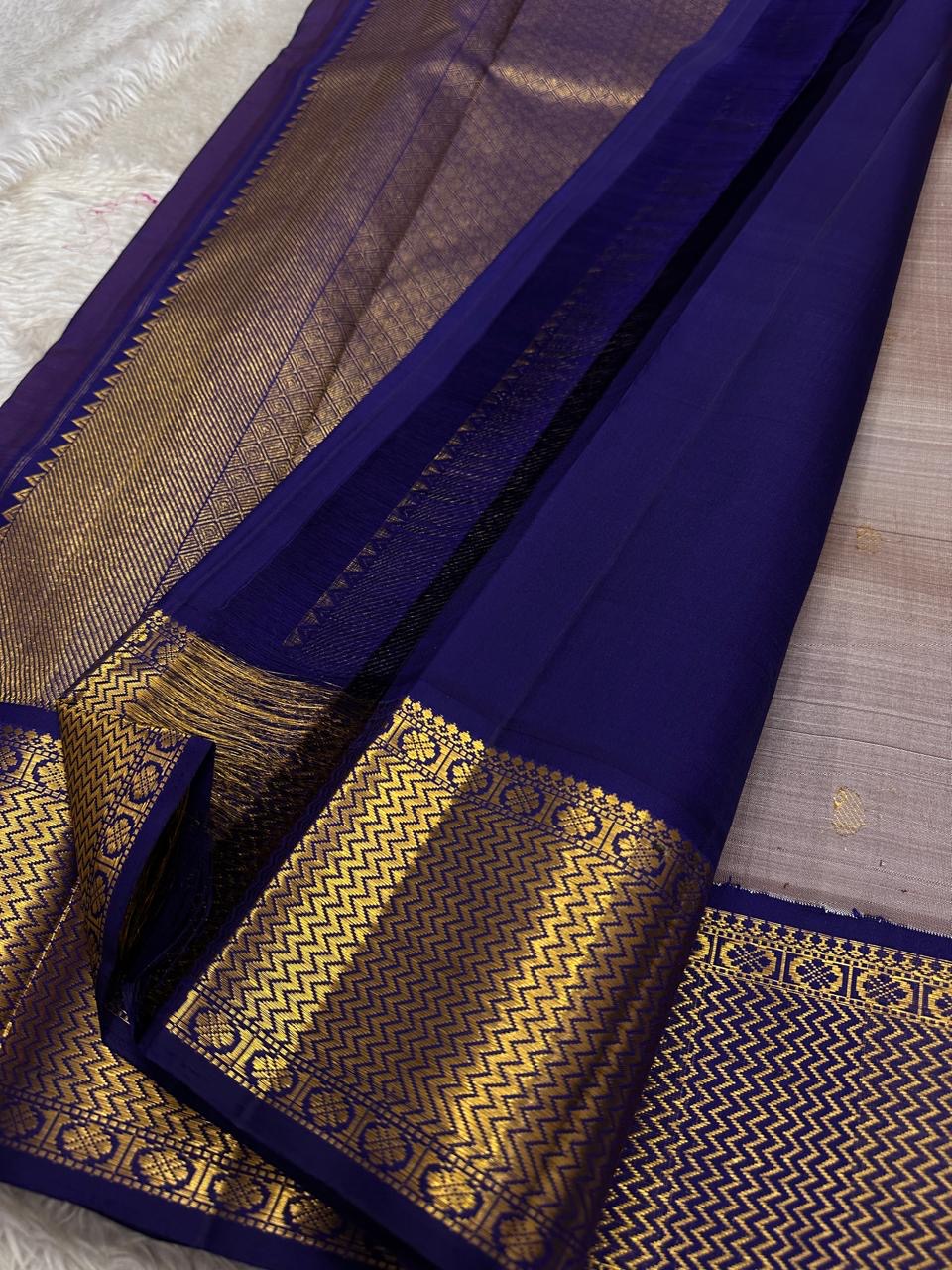 Dovetail Grey – Pure Kanchipuram Silk Saree
Dove-grey body with petite kamalam & manga zari buttas ✨
Regal violet borders in chevron zari weave 🌸
Opulent violet pallu with diamond lattice design 💜
Silk Mark Certified, delivery in 2 weeks