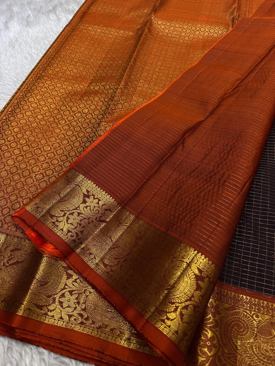 Susheela ✨ – Coffee-Brown Oosi Kattam Kanchipuram Pure Silk Saree
Korvai Burnt-Orange Border with Majestic Peacock Zari Motifs
Intricate Zari-Weave Pallu with Traditional Patterns & Highlights
Contrast Burnt-Orange Blouse Fabric with Matching Zari Border