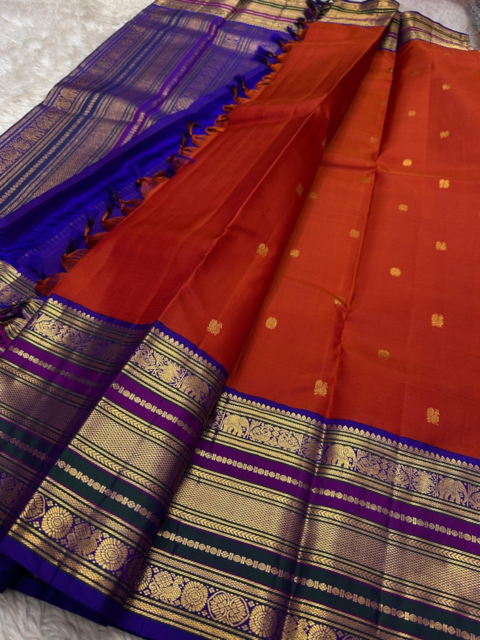 Ruby Grape Purple — Pure Silk Kanchipuram Saree
Kumkum-Red Body with Gold Buttas & Royal-Purple Elephant Zari Border ✨
Silk Mark Certified • Free USA Shipping • Ships in 2 weeks